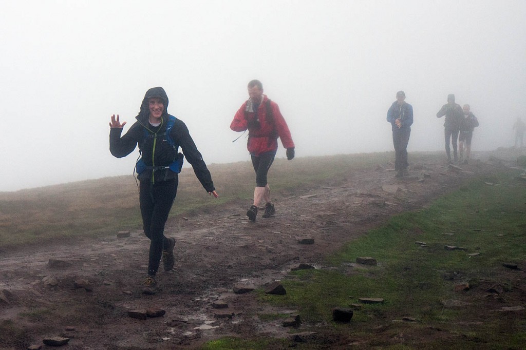 Fellsman competitors arrive at Whernside summit early in the event, during heavy rain showers