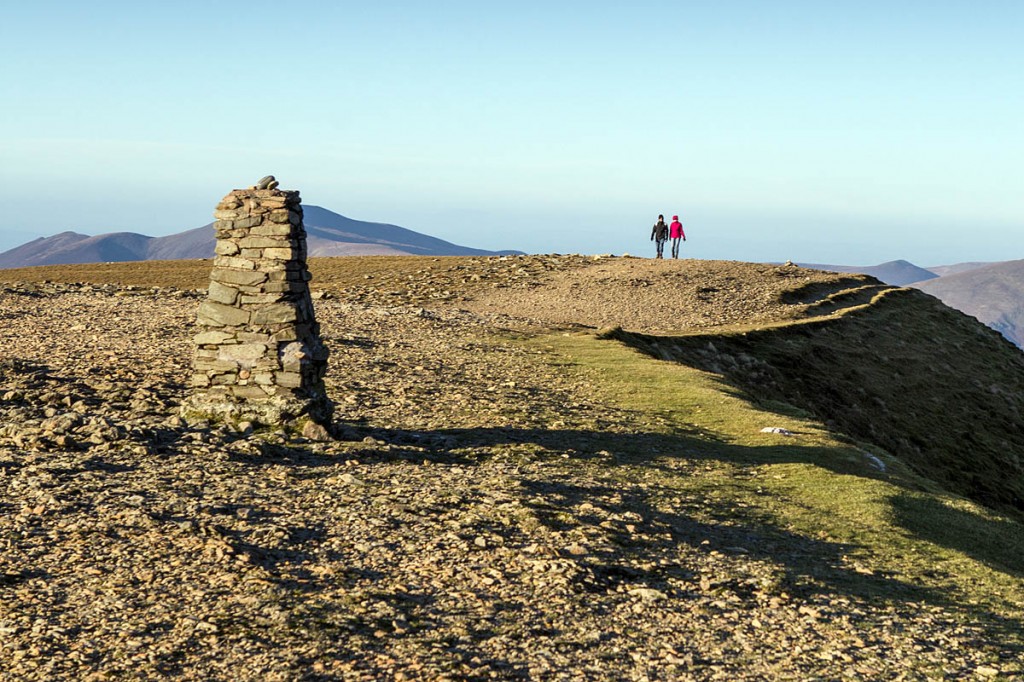 Walkers enjoy winter sunshine on the summit of Helvellyn Walkers enjoy winter sunshine on the summit of Helvellyn