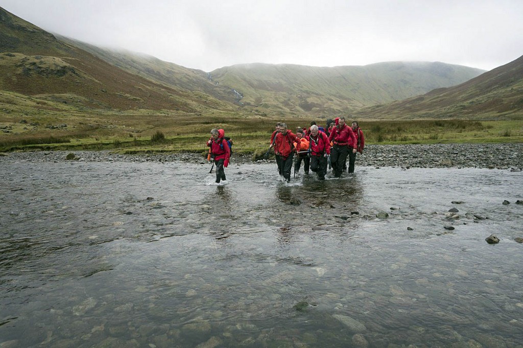 Rescuers stretcher the injured runner across Langstrath Beck. Photo: Keswick MRT Rescuers stretcher the injured runner across Langstrath Beck. Photo: Keswick MRT