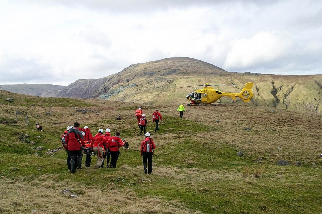 Team members stretcher the injured Base Brown walker to the air ambulance. Photo: Keswick MRT Team members stretcher the injured Base Brown walker to the air ambulance. Photo: Keswick MRT