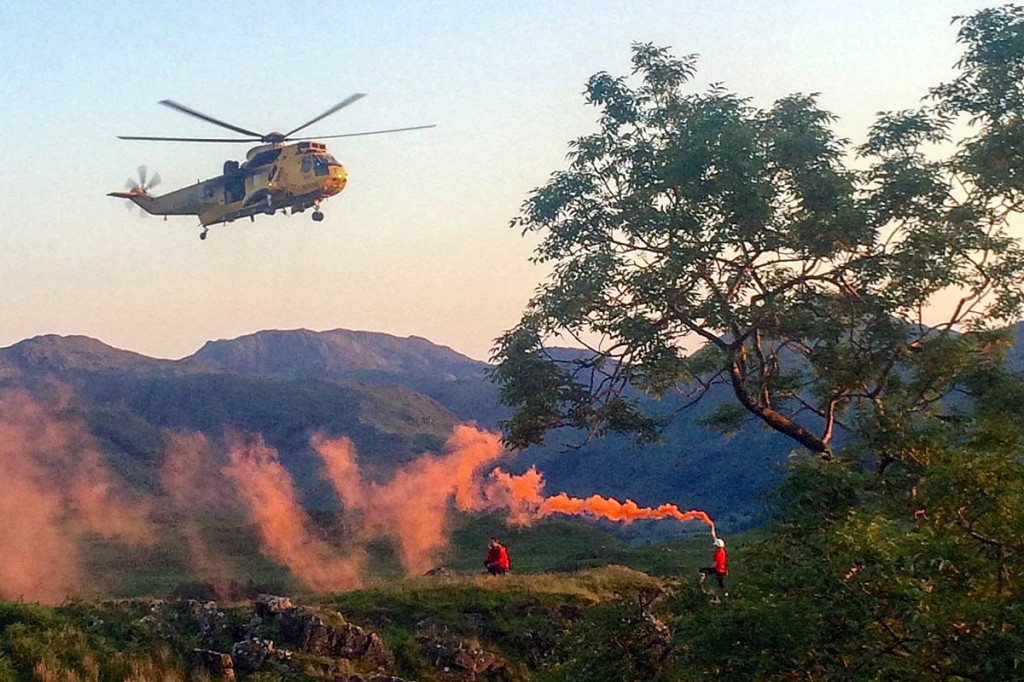 Rescuers signal to the approaching RAF Sea King at the site. Photo: Keswick MRT