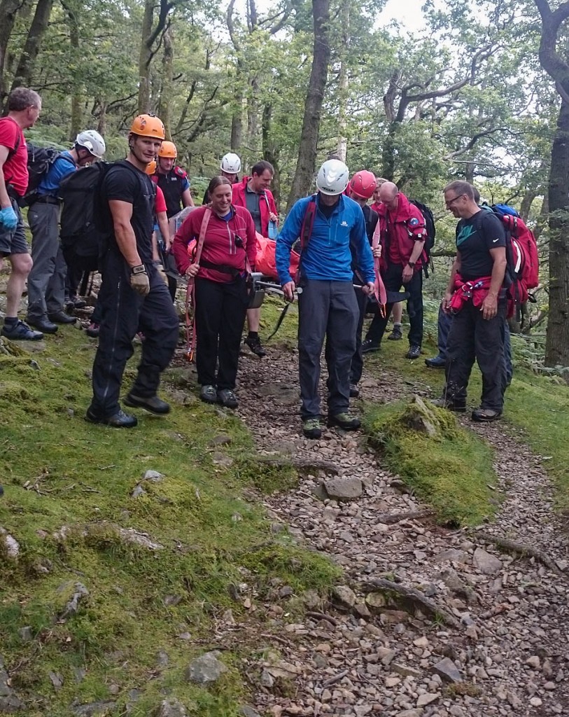 Rescuers stretcher the camper through woodland. Photo: Keswick MRT