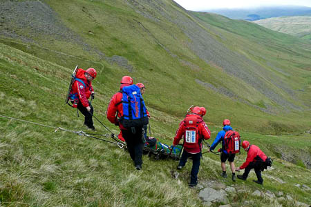 The team stretchers the injured boy from the site near Cautley Spout The team stretchers the injured boy from the site near Cautley Spout