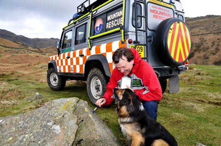 A member of the team and his search dog help at work on the project to guide benighted walkers to safety