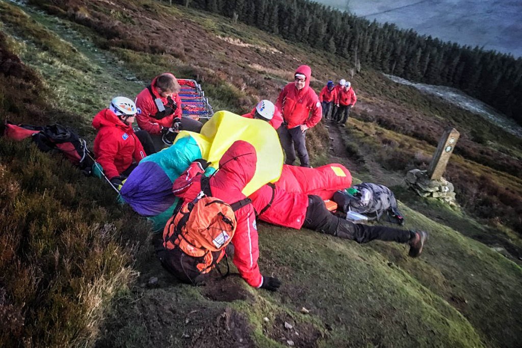 Rescue team members treat the injured walker on Foel Fenlli. Photo: Newsar Rescue team members treat the injured walker on Foel Fenlli. Photo: Newsar