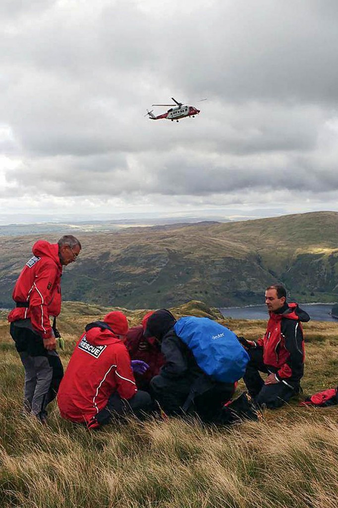 The Coastguard helicopter approaches as rescuers treat the injured man. Photo: Penrith MRT