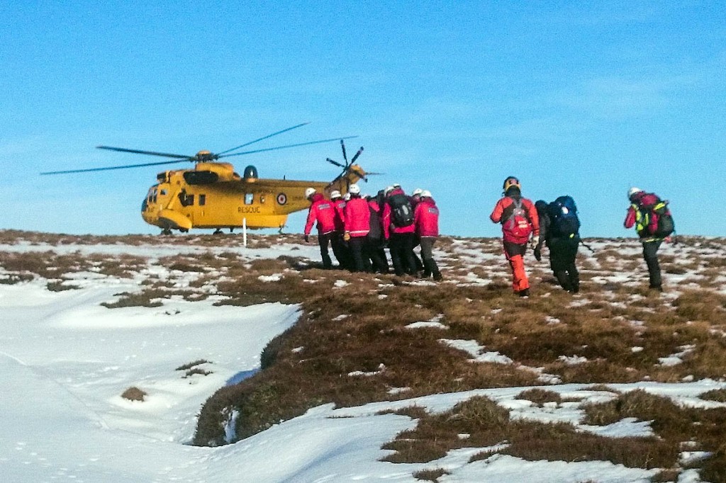 Members from Glossop and Edale teams carry the walker to the RAF Sea King. Photo: Glossop MRT