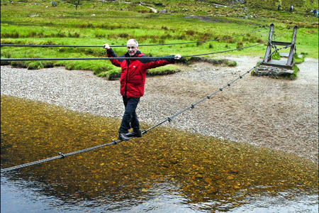 A walker crosses the Water of Nevis wire bridge. Photo: Ted and Jen CC-BY-2.0