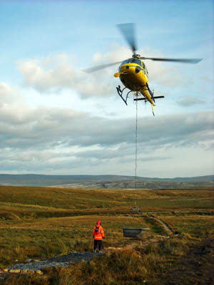 A helicopter drops the stone at the site, between Gaping Gill and Little Ingleborough. Photo: Yorkshire Dales National Park Authority
