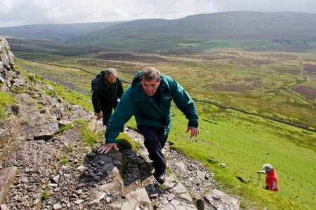 Authority chairman Carl Lis makes his ascent of Pen-y-ghent, under the watchful eye of Steve Hastie