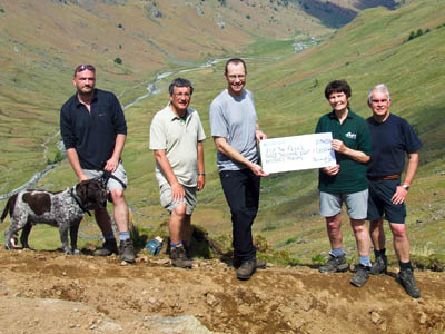 Richard Fox, centre,  receives a cheque from team leader Jenny Whalley. With them are, from left, Dik Stoddart, Derek Cockell and Martin Roberts. Photo: Ray Bradshaw