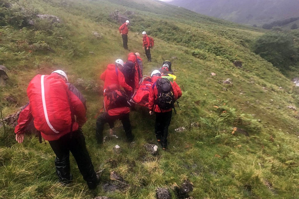 Rescuers stretcher one of the family members from the hillside. Photo: Wasdale MRT Rescuers stretcher one of the family members from the hillside. Photo: Wasdale MRT