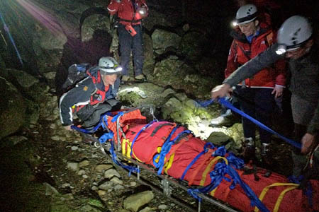 Rescuers prepare to stretcher the walker off the mountain. Photo: Wasdale MRT Rescuers prepare to stretcher the walker off the mountain