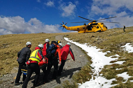 Rescuers stretcher the man to the waiting RAF helicopter. Photo: Wasdale MRT Rescuers stretcher the man to the waiting RAF helicopter
