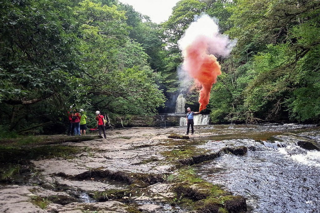 Rescue team members guide the helicopter in to the site. Photo: Western Beacons MSRT
