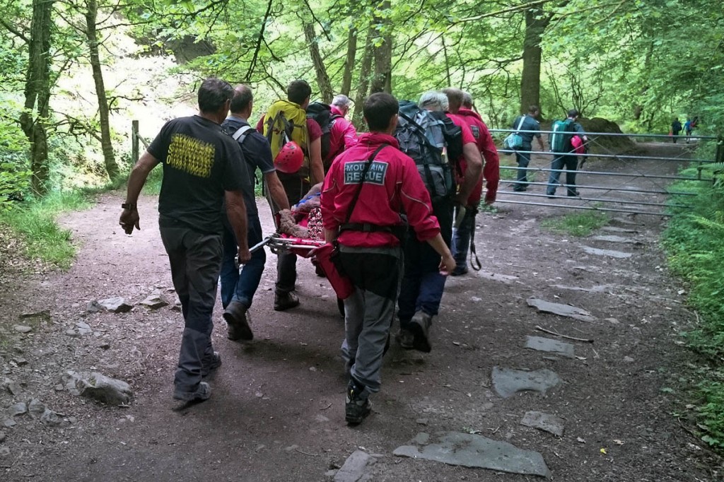 Rescuers carry the man from the site. Photo: Western Beacons MSRT